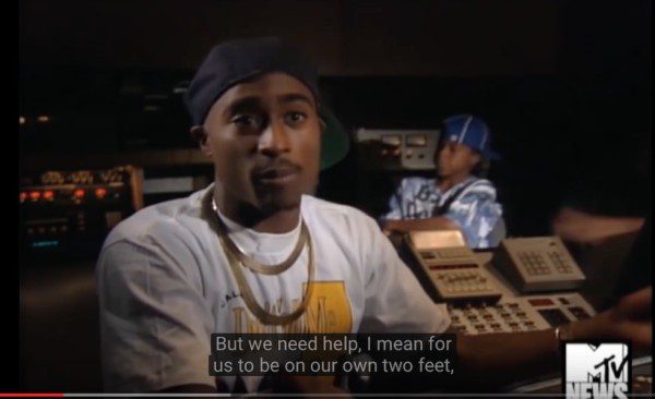 Tupac in a white shirt, gold chains